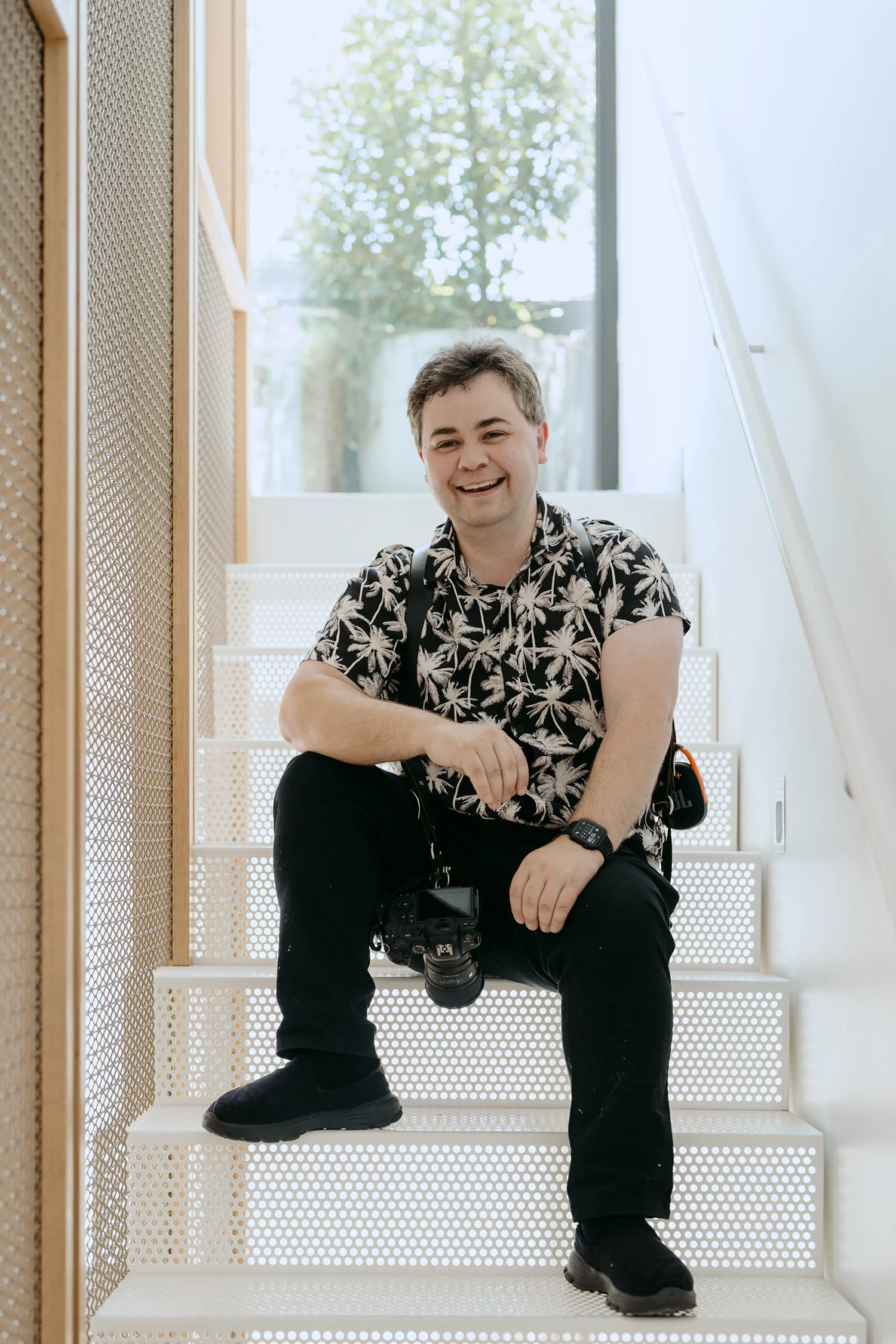 Glen Mackay, wedding filmmaker, sitting on a staircase
